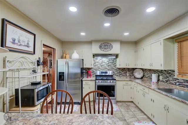 a kitchen with stainless steel appliances kitchen island granite countertop a sink and cabinets
