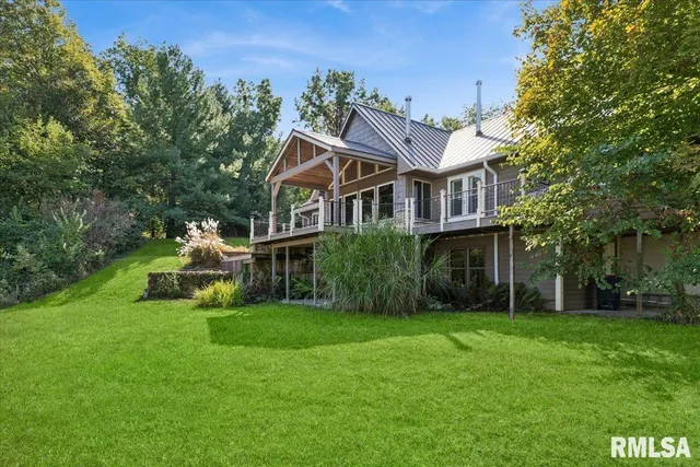 a house that has a big yard with potted plants and big trees