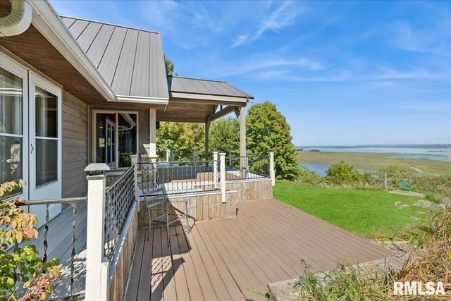 a view of a patio with lawn chairs next to a yard