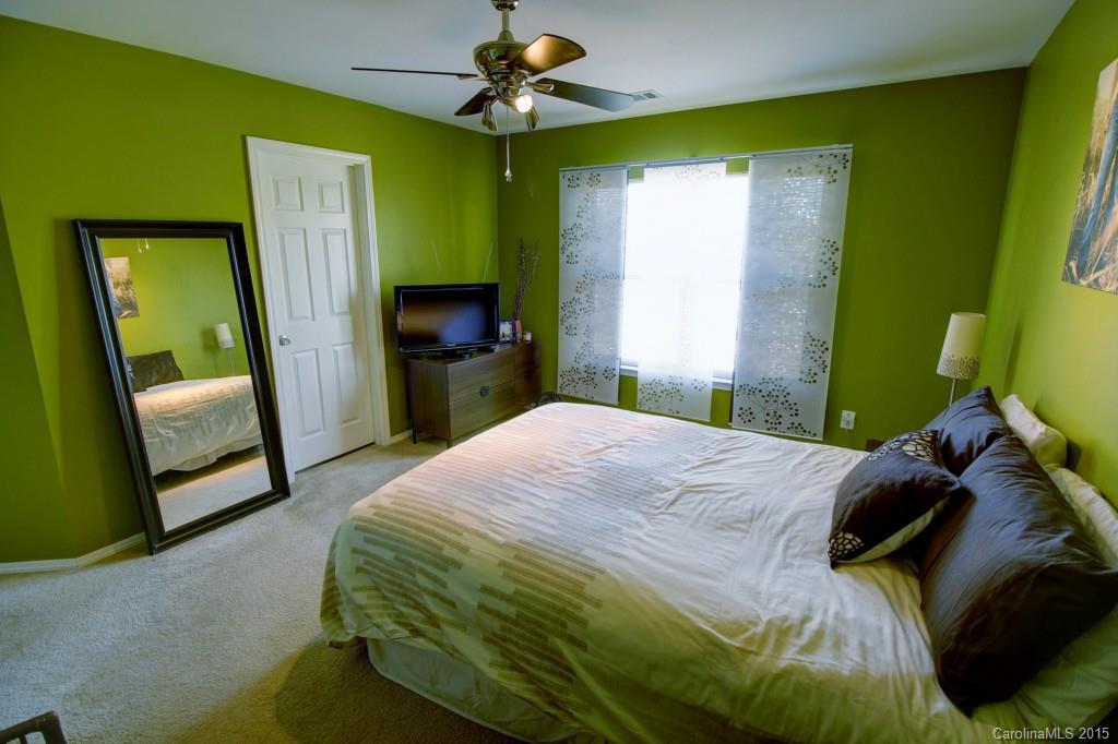 290 River Clay Road, Unit 222 Fort Mill, SC 29708 - Photo 11 of 12 a bedroom with a bed a mirror on the dresser and a flat screen tv