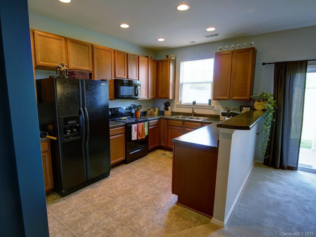 290 River Clay Road, Unit 222 Fort Mill, SC 29708 - Photo 4 of 12 a kitchen with stainless steel appliances granite countertop refrigerator a sink a stove a washer dryer and a refrigerator