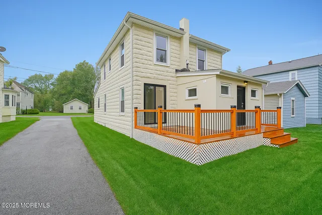 a view of a house with a yard and a deck