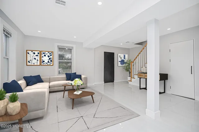 a living room with furniture and view of kitchen