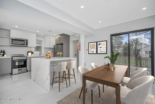 a kitchen with a table chairs microwave and cabinets