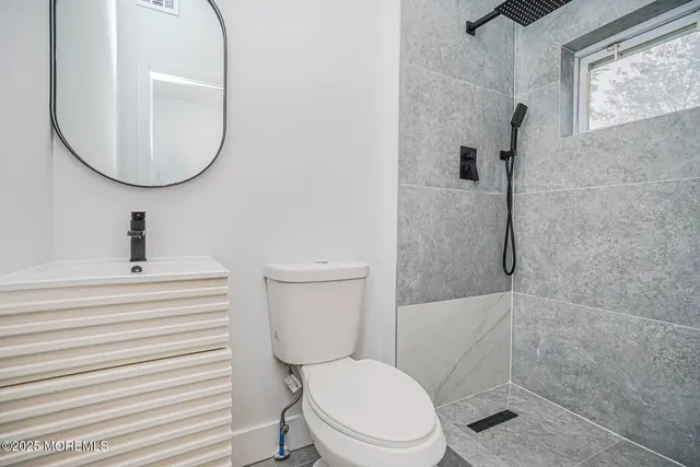 a bathroom with a toilet a sink and a mirror