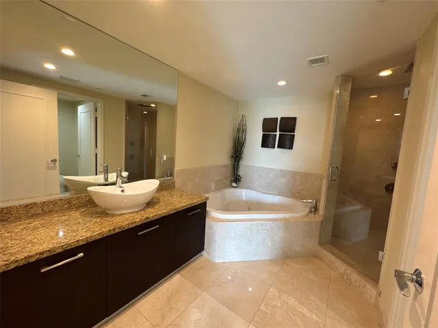 a bathroom with a granite countertop sink a toilet a mirror and bathtub