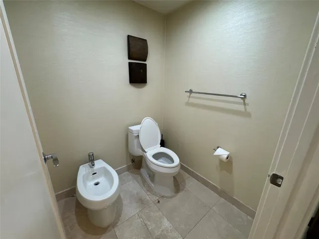 a white toilet sitting next to a bathroom sink