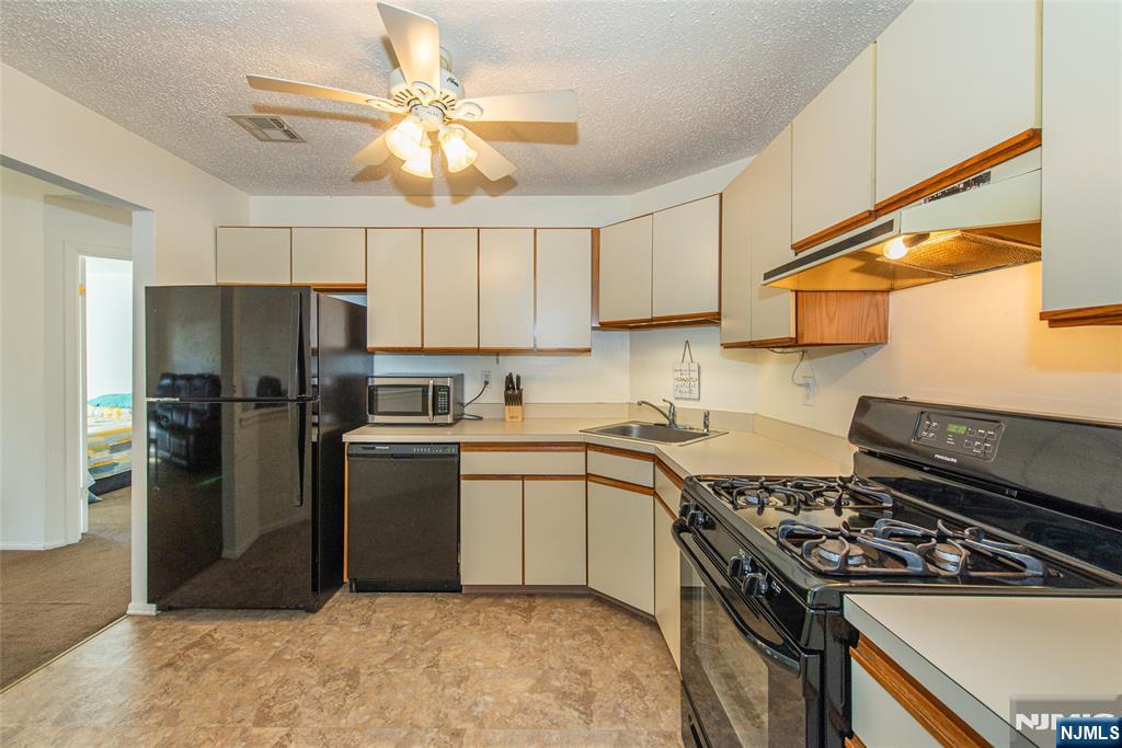 7 Drake Lane Roxbury Township, NJ 07852 - Photo 10 of 35 a kitchen with a stove a sink and a refrigerator