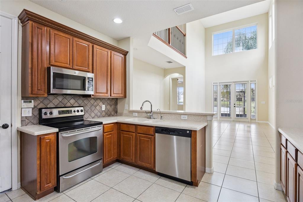 551 Terrace Spring Drive Orlando, FL 32828 - Photo 3 of 41 a kitchen with a sink stove and microwave