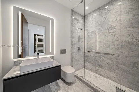 a bathroom with a granite countertop sink toilet a mirror and shower