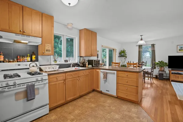 a kitchen with sink cabinets and flat screen tv