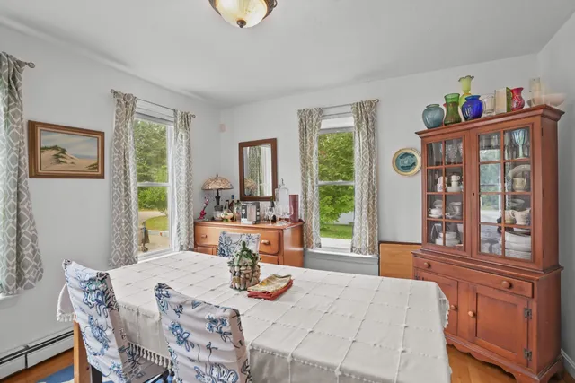 a view of a dining room with furniture a chandelier and wooden floor
