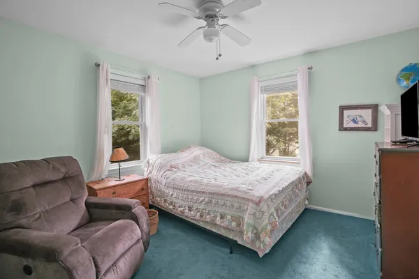 a bedroom with a bed couch and window