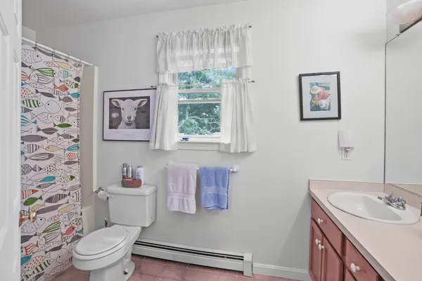 a bathroom with a toilet a sink and a window