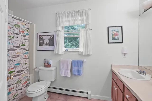 a bathroom with a toilet a sink and a window