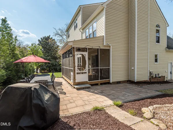 a patio with table and chairs and potted plants