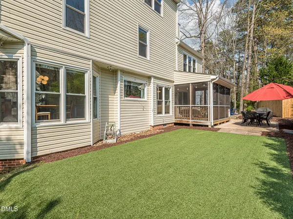 a view of a house with backyard and sitting area