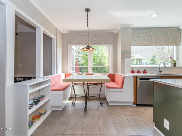 a kitchen with kitchen island a stove a sink a refrigerator and a dining table