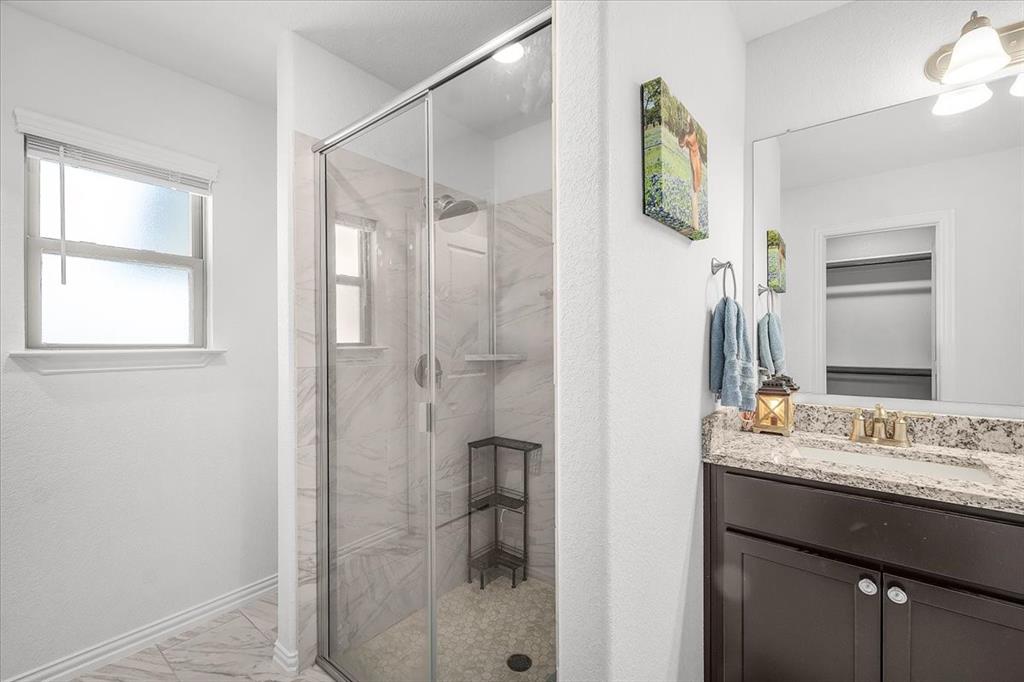 3797 Pine Road Poolville, TX 76487 - Photo 13 of 22 a bathroom with a granite countertop sink a mirror and shower