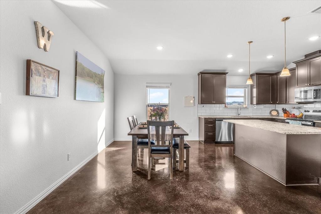 3797 Pine Road Poolville, TX 76487 - Photo 8 of 22 a kitchen with kitchen island granite countertop a sink cabinets and wooden floor
