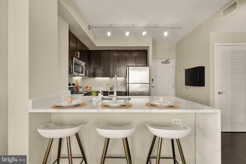 a kitchen with stainless steel appliances kitchen island granite countertop a sink and cabinets