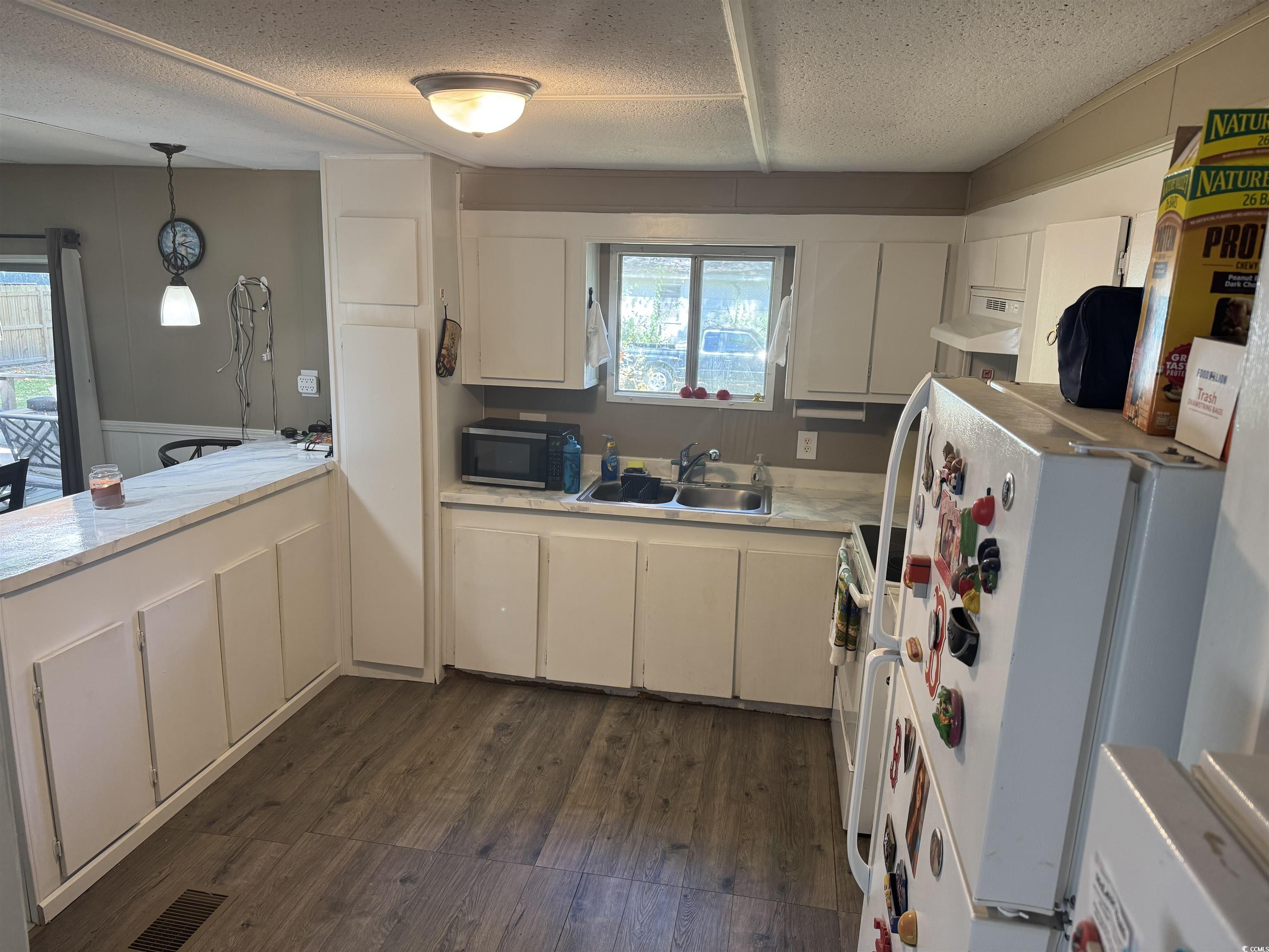 500 Palmetto Street Conway, SC 29527 - Photo 5 of 17 Kitchen featuring light countertops, dark wood-type flooring, white cabinets, white appliances, and a textured ceiling