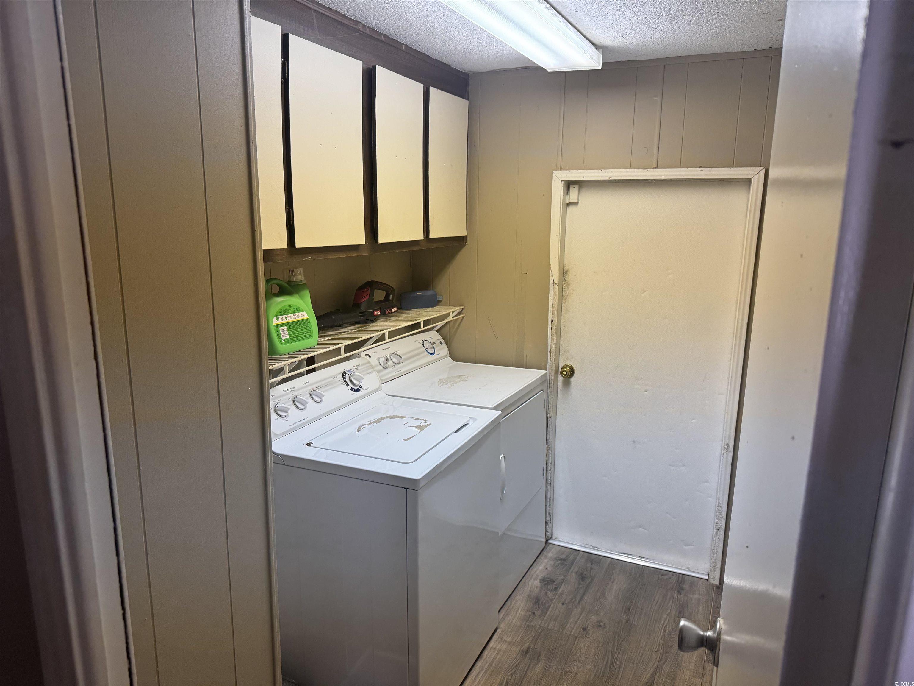 500 Palmetto Street Conway, SC 29527 - Photo 7 of 17 Washroom with dark wood-style floors, a textured ceiling, cabinet space, separate washer and dryer, and wooden walls