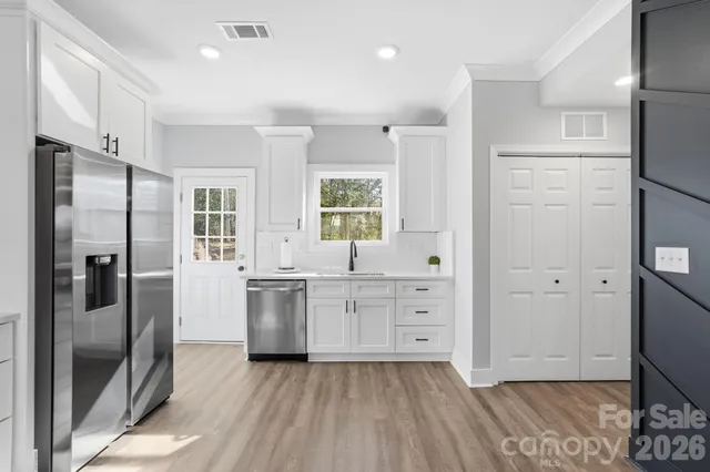a kitchen with stainless steel appliances a refrigerator sink and cabinets