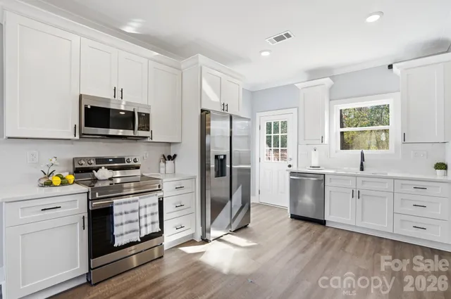 a kitchen with white cabinets and stainless steel appliances