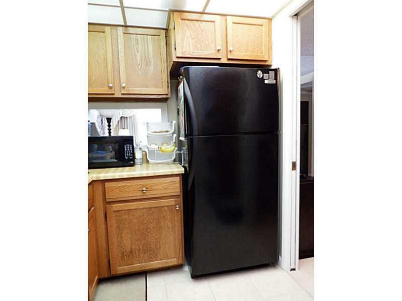 3750 Inverrary Drive, Unit 2Q Lauderhill, FL 33319 - Photo 9 of 16 a kitchen with stainless steel appliances a refrigerator and cabinets