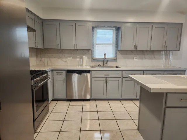 a kitchen with a sink stove top oven and cabinets