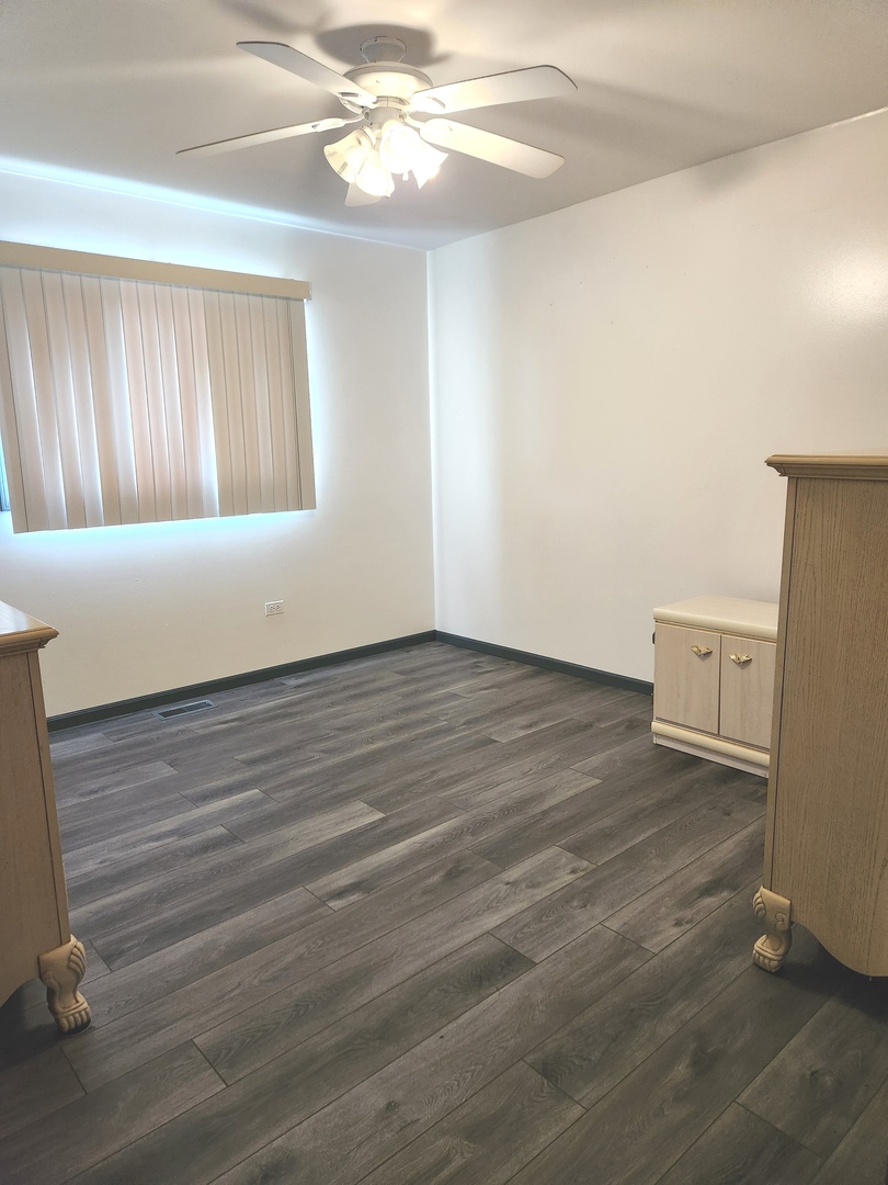 11723 South Ave J Chicago, IL 60617 - Photo 16 of 32 a view of an empty room with wooden floor and a window
