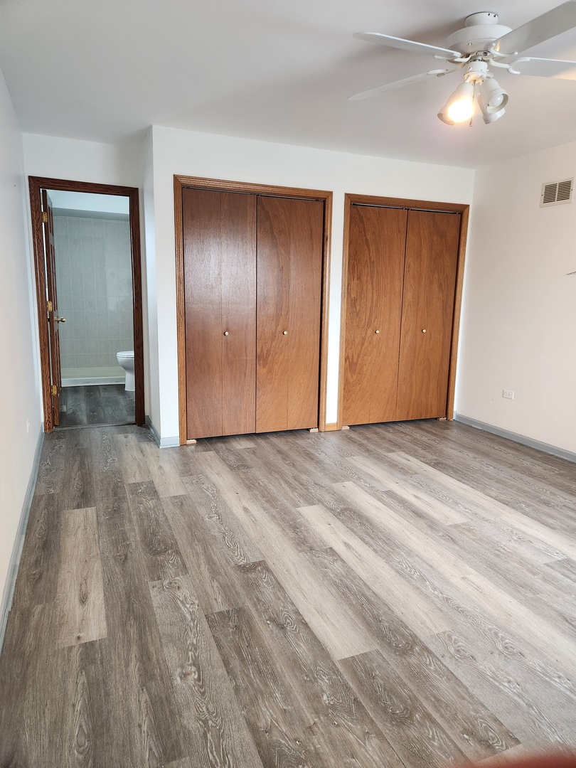 11723 South Ave J Chicago, IL 60617 - Photo 20 of 32 a view of an empty room with wooden floor and closet area