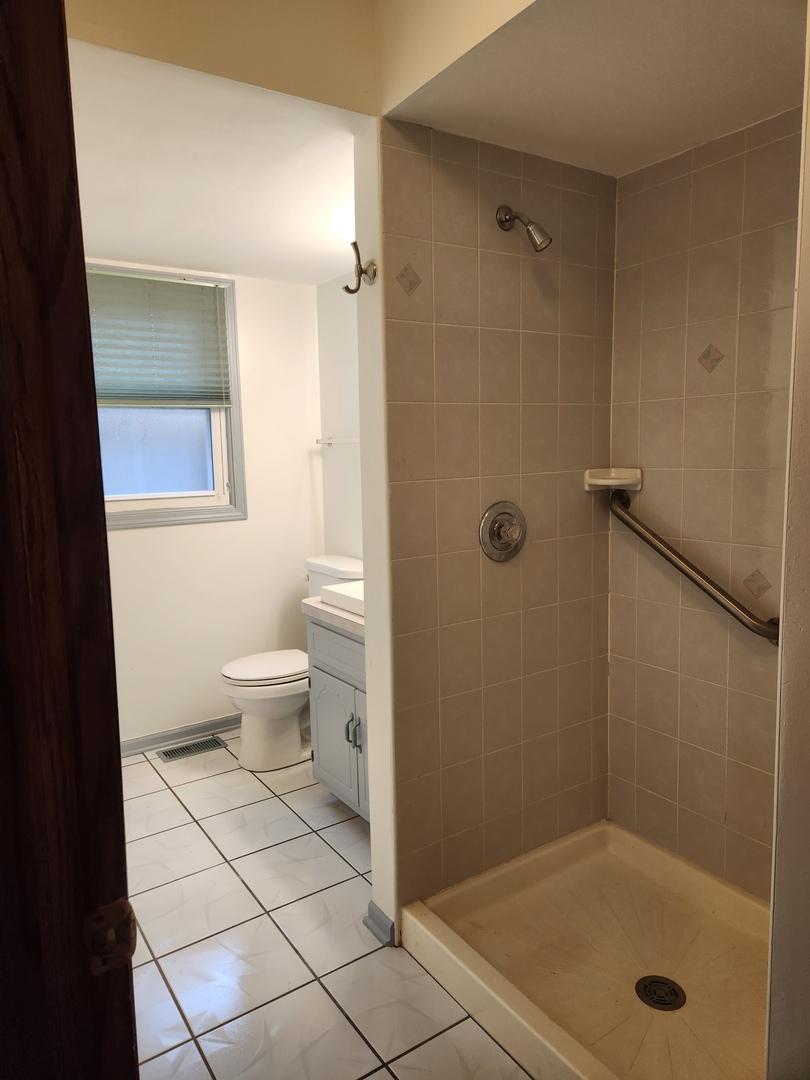 11723 South Ave J Chicago, IL 60617 - Photo 24 of 32 a bathroom with a granite countertop sink toilet and shower