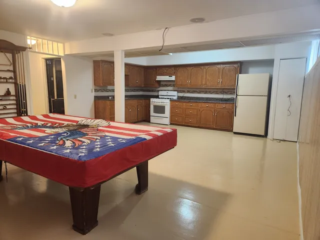 a kitchen with kitchen island a counter top space a sink stainless steel appliances and cabinets