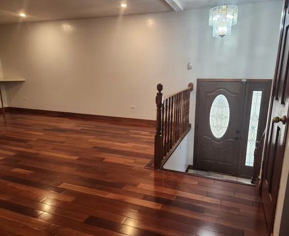 a view of a room with wooden floor and white walls