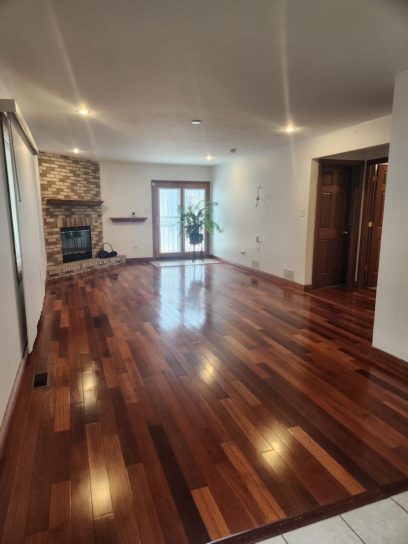 11723 South Ave J Chicago, IL 60617 - Photo 4 of 32 a view of an empty room with wooden floor and a window