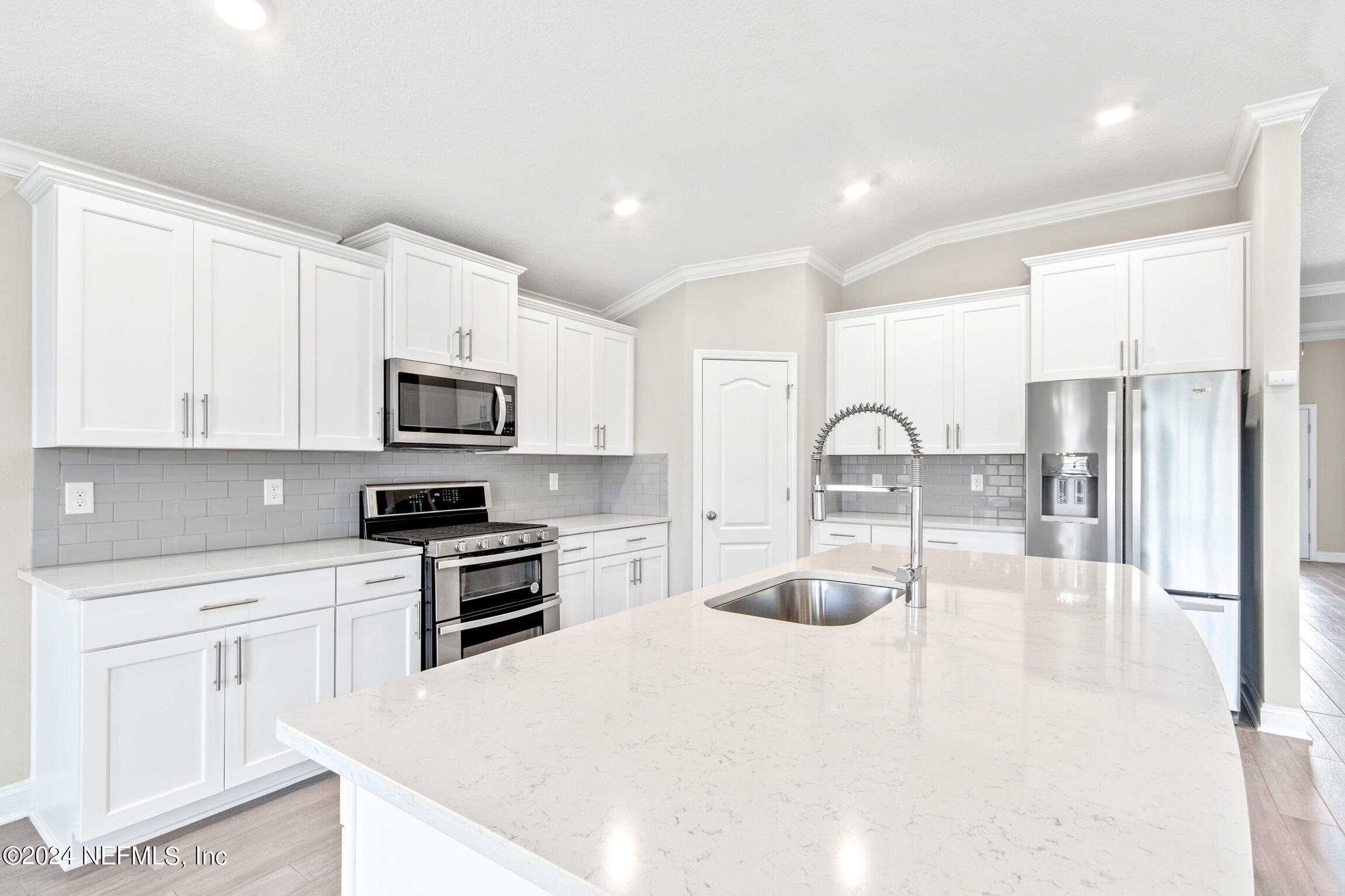 254 Ebro Road St. Augustine, FL 32084 - Photo 4 of 49 a kitchen with stainless steel appliances granite countertop a refrigerator a stove a sink and white cabinets with wooden floor