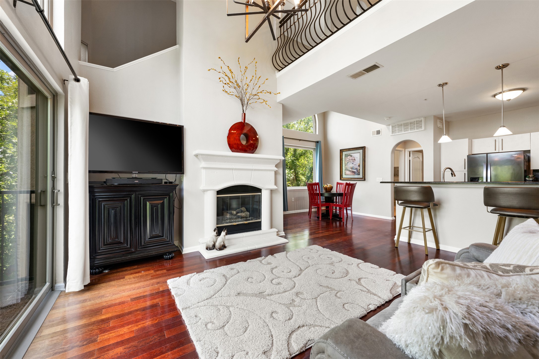 11203 Ranch Road 2222, Unit 1407 Austin, TX 78732 - Photo 20 of 40 The living room centers around a striking gas long fireplace and opens to the second floor living area above.