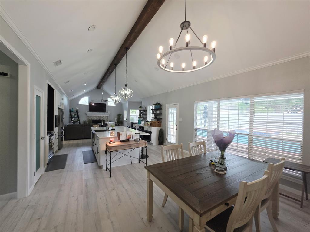 520 Red River Road Belton, TX 76513 - Photo 23 of 36 Expansive open-concept living area featuring high vaulted ceilings with exposed wood-finish beam, light wood-finish flooring, and a contemporary dining chandelier