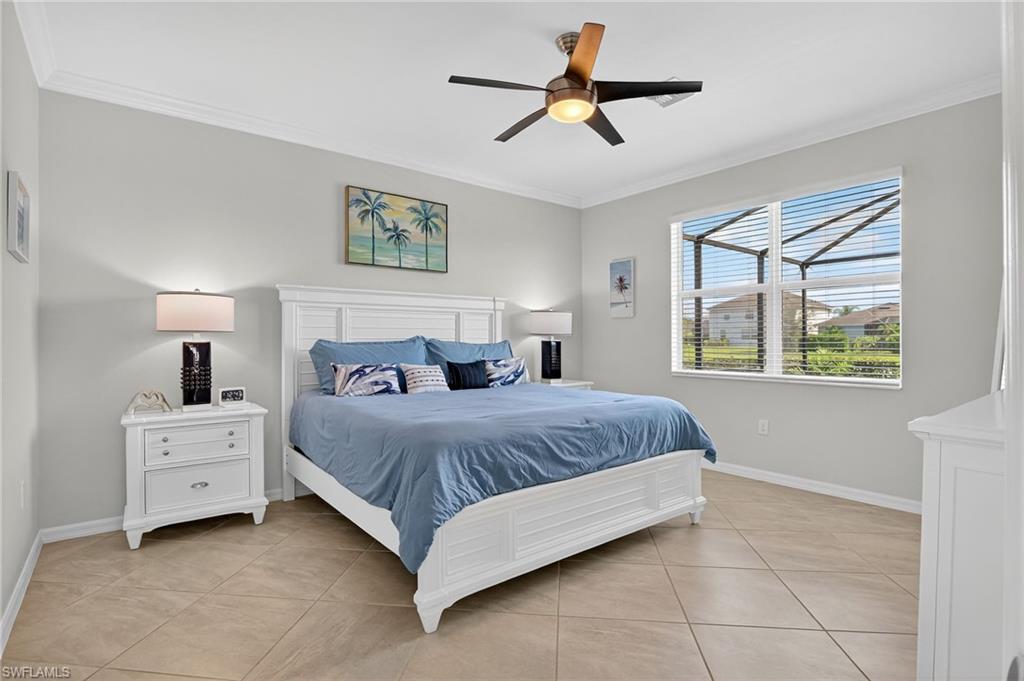 2130 Hamlin Street Naples, FL 34120 - Photo 11 of 43 a spacious bedroom with a bed a window and a chandelier