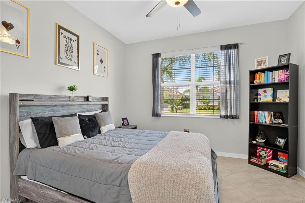 2130 Hamlin Street Naples, FL 34120 - Photo 19 of 43 a bedroom with a bed and a bookshelf with wooden floor