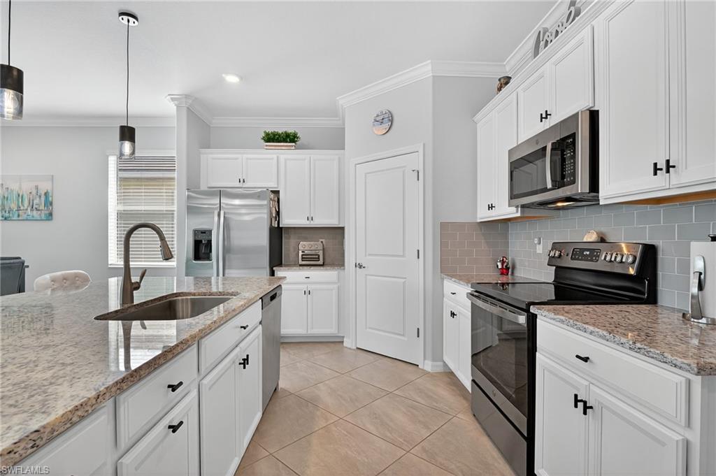 2130 Hamlin Street Naples, FL 34120 - Photo 26 of 43 a kitchen with stainless steel appliances granite countertop a sink a stove and a refrigerator