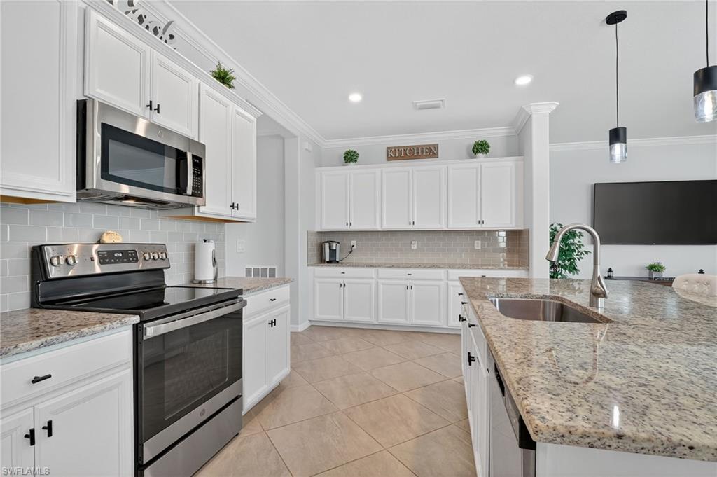 2130 Hamlin Street Naples, FL 34120 - Photo 9 of 43 a kitchen with stainless steel appliances granite countertop a sink and stove top oven