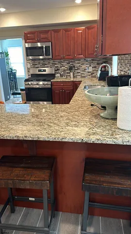 a kitchen with a stove a sink and a wooden cabinets