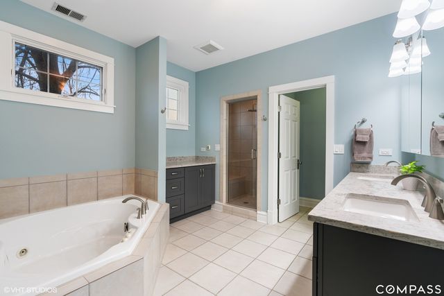 a bathroom with a tub a sink and a mirror