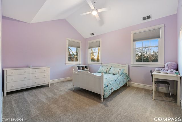 a spacious bedroom with a bed and a table chair