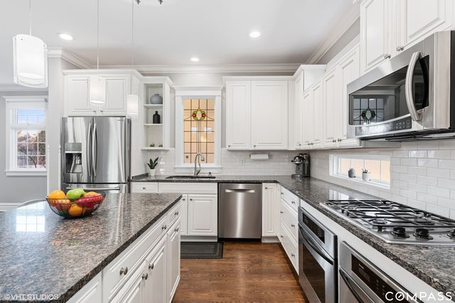 a kitchen with stainless steel appliances granite countertop a sink dishwasher stove top oven and refrigerator