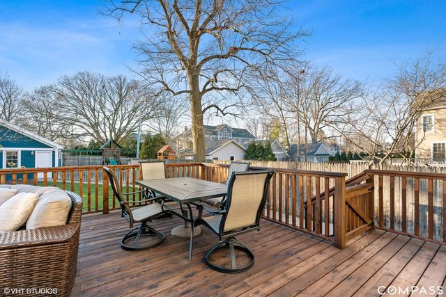 a view of a roof deck with table and chairs with wooden floor and fence