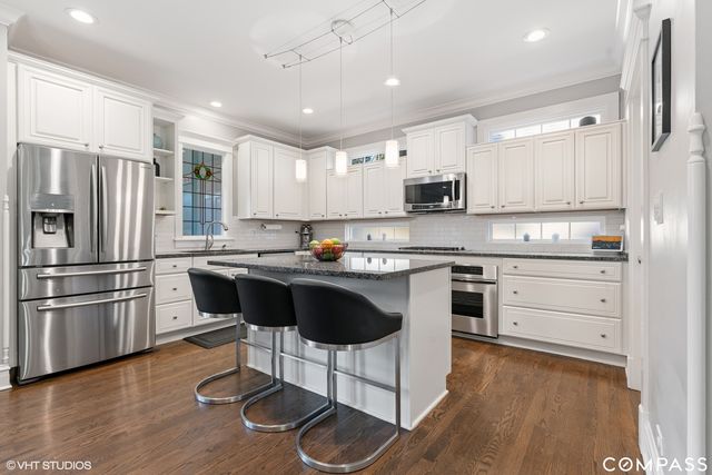 a kitchen with a refrigerator and a stove top oven
